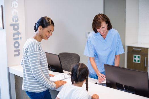 Nurse talking with a patient at counter in hospital