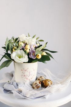 Easter eggs with green branches and yellow berries on white and gray background. Happy Easter holiday, front view.