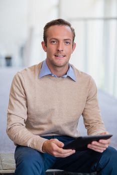 Portrait of a businessman holding digital tablet at conference centre