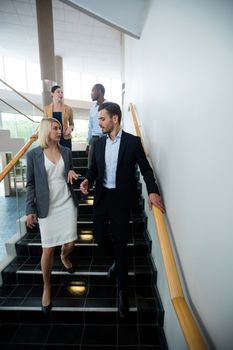Business executives walking down the stairs at conference center