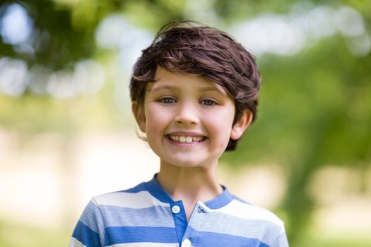 Portrait of innocent boy smiling in park on a sunny day