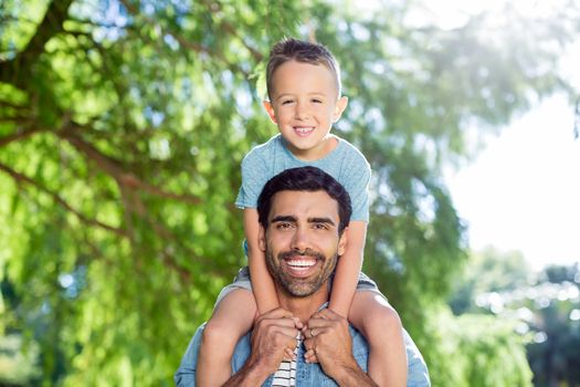 Father carrying son on his shoulders in the park