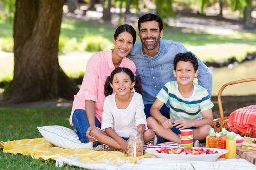 Happy family having breakfast in park on a sunny day