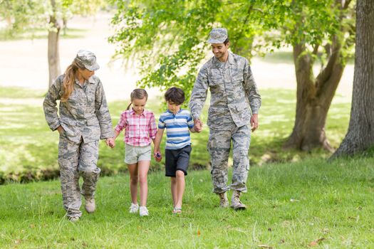 Military couple with their kids in park on a sunny day
