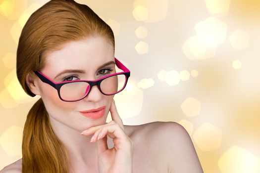 Beautiful redhead posing with glasses against yellow abstract light spot design