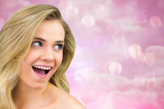 Smiling blonde natural beauty against digitally generated pink girly design