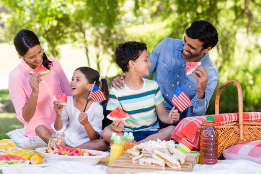 Happy family having breakfast in a park on a sunny day