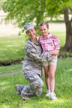 Portrait of happy female soldier with her daughter in park on a sunny day