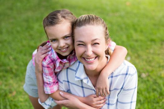 Happy mother holding hands of her daughter in park