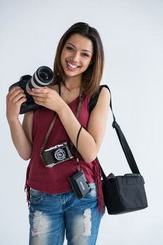 Portrait of happy female photographer standing in studio