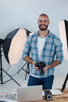 Portrait of male photographer working at desk in studio