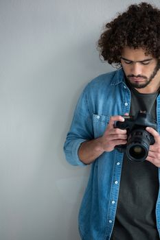 Male photographer reviewing captured photos in her digital camera at studio