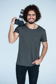 Portrait of happy photographer holding a camera in the studio