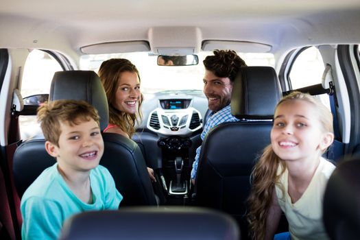 Portrait of happy family sitting in car