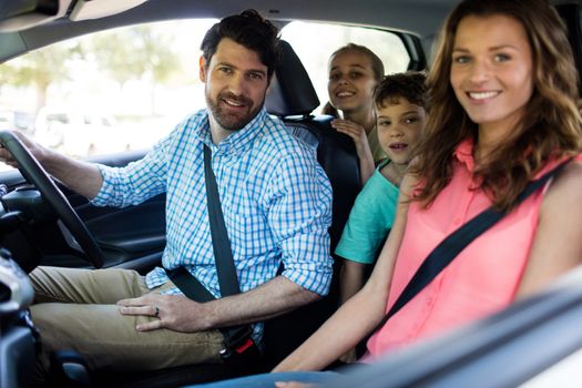 Portrait of happy family sitting in car