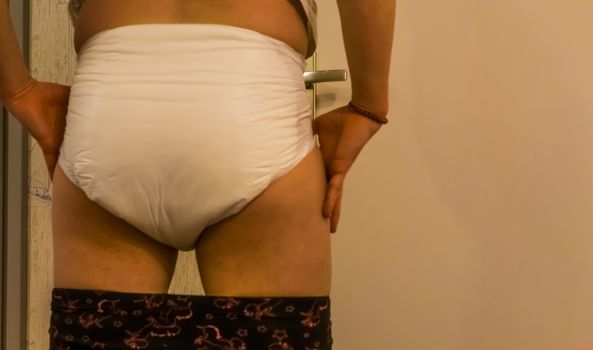 rear view of a adult person wearing a wet adult diaper, Incontinence products and solutions, medical bladder control issues