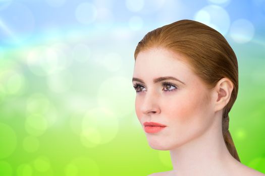 Beautiful redhead posing with hair tied against green and blue abstract design