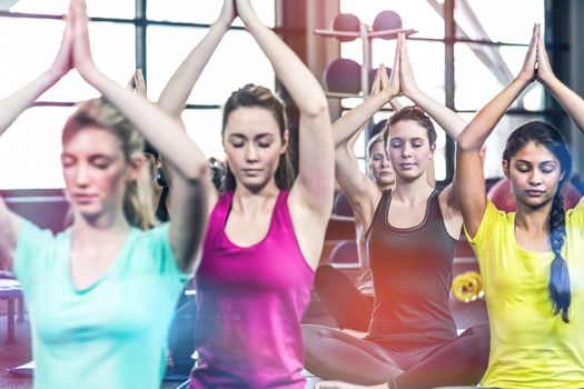 Fit smiling group doing yoga in gym