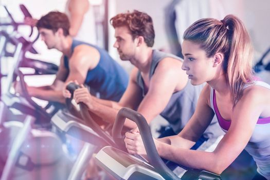 Fit people doing exercise bike at gym