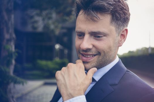 Close up of thoughtful businessman smiling outdoors