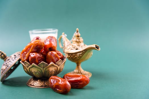Ramadan, Dates in golden bowl, Milk, arabian Aladdin golden lamp vintage style on black green background