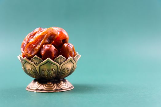 Ramadan, Dates in golden bowl vintage style on black green background