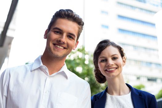 Portrait of businessman and woman smiling outdoors