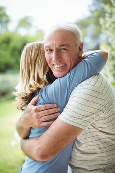 Senior couple embracing outdoors	Smiling senior couple embracing outdoors