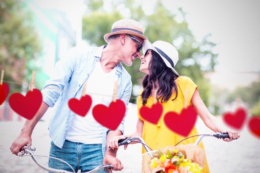 Hearts hanging on a line against romantic couple looking at each other