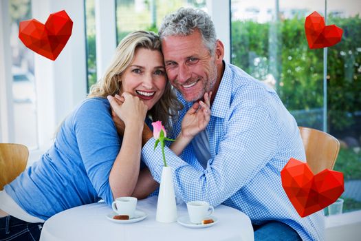 Heart against portrait of romantic couple in restaurant 3d