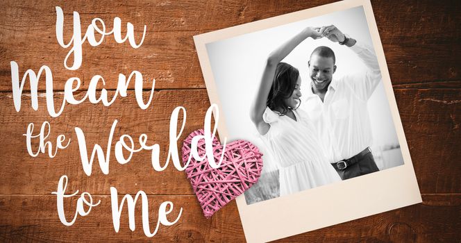 Romantic couple dancing and smiling against overhead of wooden planks