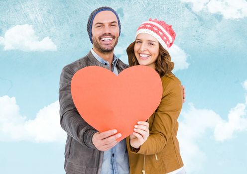 Romantic couple holding a heart against sky