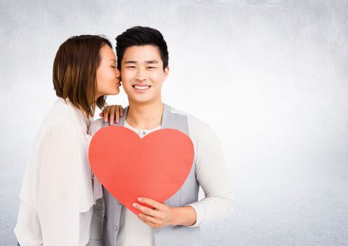 Romantic couple holding heart shape, woman kissing man