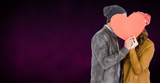 Romantic couple hiding their face behind heart against purple background