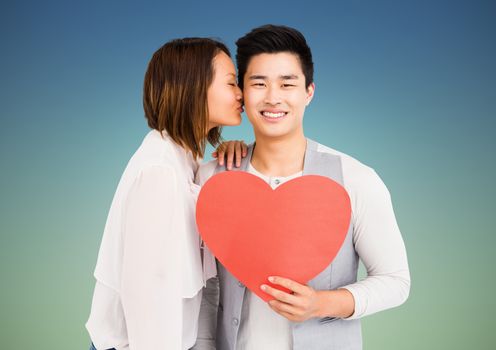 Romantic couple holding heart shape, woman kissing man