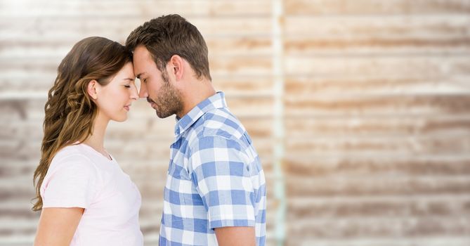 Romantic couple standing with closed eyes against wooden background