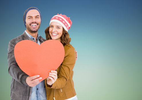 Romantic couple holding a heart against blue background