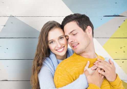 Romantic couple embracing against wooden background