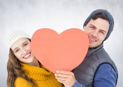 Romantic couple holding a heart against white background
