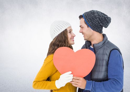 Romantic couple holding a heart against white background