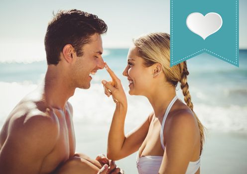 Romantic couple at the beach with digitally generated heart