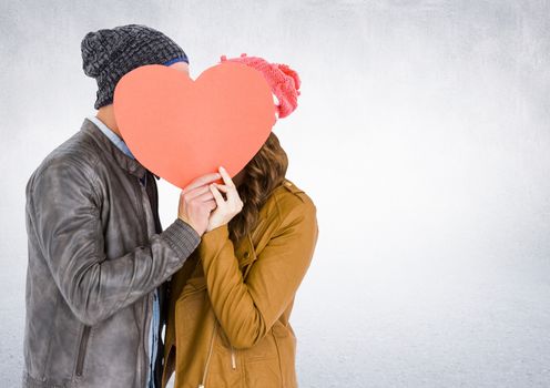 Romantic couple holding heart shape and kissing each other against white background