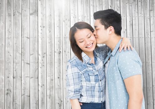 Romantic man kissing woman against wooden background