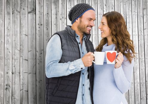 Romantic couple holding mug against wooden background