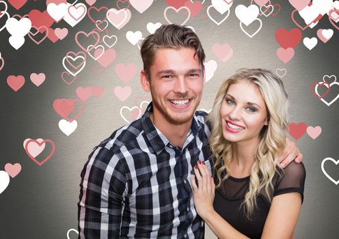 Composite images of romantic couple smiling with heart shapes on background