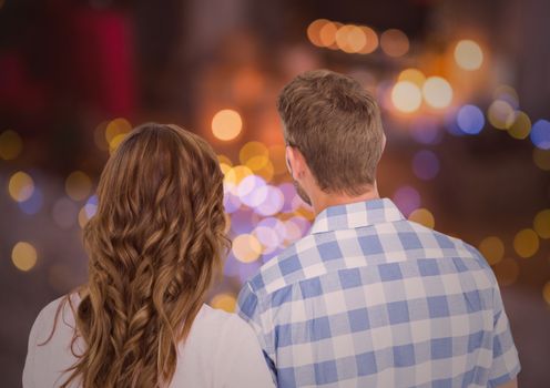 Rearview of romantic couple looking at night bokeh