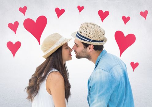 Romantic couple kissing each other against digitally generated heart background