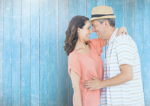 Romantic couple standing against blue wooden background