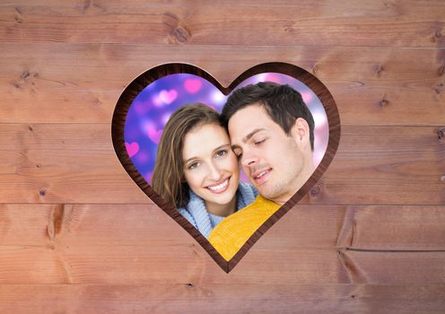 Romantic couple in heart frame against wood background