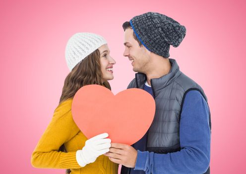 Romantic couple holding a heart against pink background